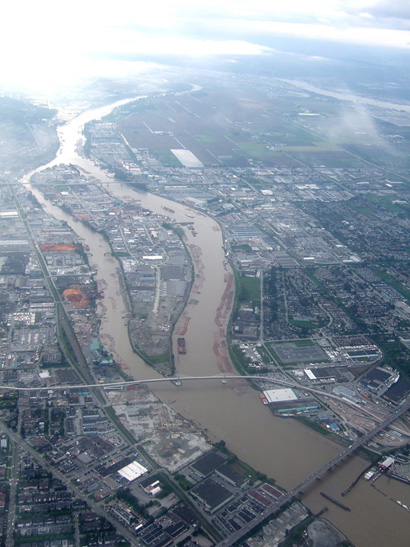 Photo of a heavily developed, urban Mitchell Island that is in the middle of the silty Lower Fraser River. No pristine natural habitat is visible.