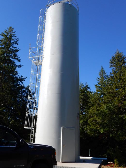 Le doseur de chaux au centre est une grande structure cylindrique avec une porte au niveau du sol et des escaliers qui montent sur le côté.